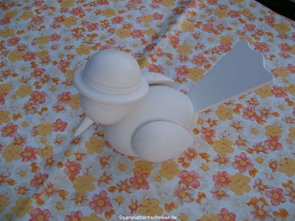 Vogel mit Hut aus Holz.