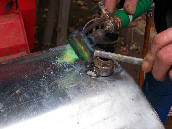 Ein Techniker baut lötet zwei Metallstücke zusammen.