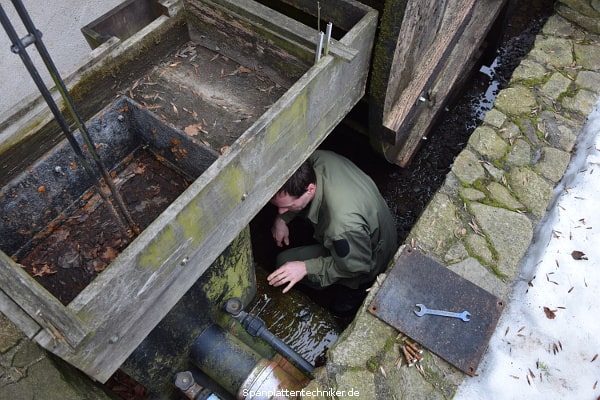 Ein Techniker arbeitet am Wasserkasten.